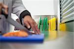 Chef cutting raw salmon with knife in professional kitchen