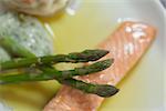 Overhead close up of salmon dish with asparagus on white plate