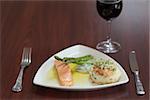 Front view of salmon dish with asparagus on wooden table