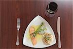 Overhead view of salmon dish with asparagus and red wine on wooden table