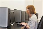 Mature female student in computer class sitting in front of  a computer