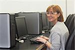 Smiling female mature student using a computer looking at camera