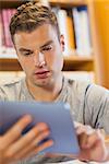 Attractive focused student using tablet in library