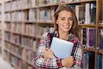 Pretty cheerful student holding tablet in library