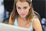 Serious pretty student working on computer in computer room at college