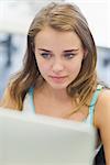 Focused pretty student working on computer in computer room at college