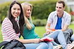 Group of three young college students sitting in the park