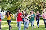 Full length of a group of college students running in the park