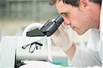 Side view Close up of a male scientific researcher using microscope in the laboratory