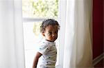 Toddler standing beside window