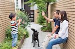 Family with dog, father waving to son