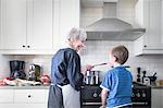 Grandmother and grandson preparing food at home