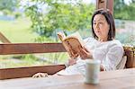 Woman reading book on patio