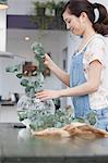 Young woman selecting foliage for vase arrangement