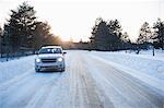 Car driving along road in snow