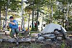 Mature man cooking on campsite, Bath, Maine, USA