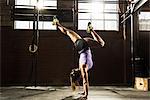 Young woman in gym doing handstand