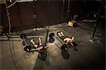 Two young adults in gym doing push ups