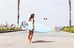 Woman with surfboard, Hermosa Beach, California, USA