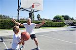 Boy and grandfather playing basketball