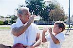 Man and grandson drinking bottled water together