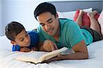 Father and son reading on bed