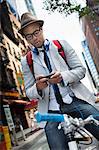 Young man on bike using smartphone