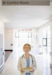 Doctor looking up at sign in hospital corridor