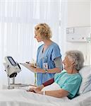 Nurse checking equipment in aging patient's hospital room