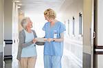 Nurse and senior patient talking in hospital corridor