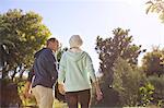 Senior couple holding hands and walking in park