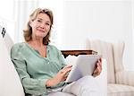 Portrait of senior woman using digital tablet on sofa