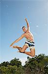 Man in swim trunks jumping