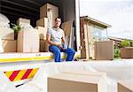 Man sitting in moving truck in driveway