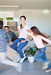 Parents watching children run around living room in new house