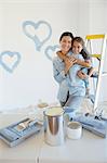 Mother and daughter hugging among paint supplies