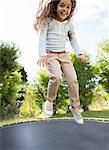 Girl jumping on trampoline outdoors