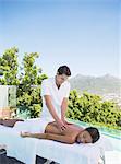 Woman receiving massage on spa patio