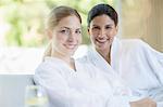 Portrait of smiling women in bathrobes at spa