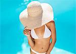 Woman wearing straw hat at poolside