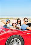 Portrait of smiling family in convertible at beach