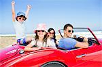 Family in convertible at beach