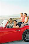 Family in convertible on beach