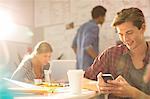 Businessman using cell phone in office