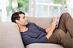 Man using digital tablet on sofa