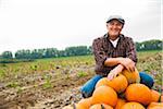 Farmer in field, next to pumpkin crop, Germany