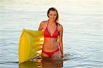 Young woman with airbed in a lake