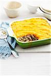 Shepherds Pie in baking dish on table with serving spoon