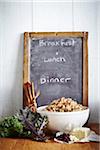 Menu Board with kale, cinnamon, cranberries, tofu and bowl of quinoa, studio shot