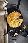 Cheesy Bannock bread in baking pan on grey background, studio shot